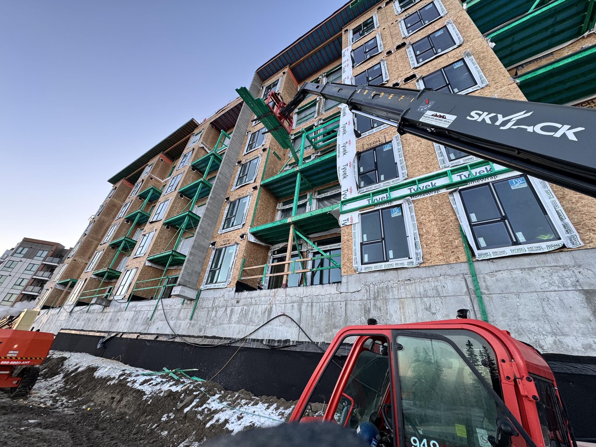 Four-storey wood-frame walk-up over concrete podium